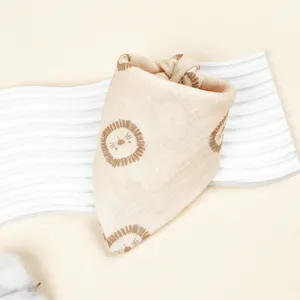 Cotton muslin baby bandana bib detail view featuring cute cartoon lion print and soft texture.