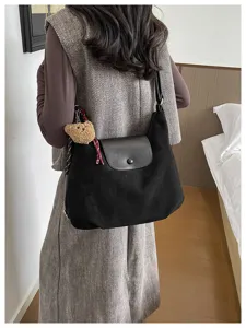 Trendy black shoulder bag with cute bear pendant, stylish underarm bag for women daily commute.