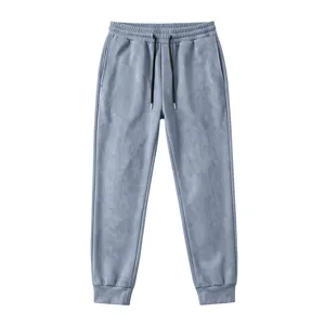 Detail view of men's grey suede sweatpants, featuring elastic drawstring waist and cuffed ankles.