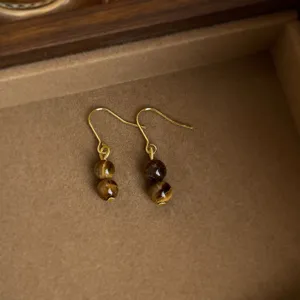 Detailaufnahme retro braune Tigerauge Stein Ohrhaken, elegante Vintage Asthetik Schmuck.