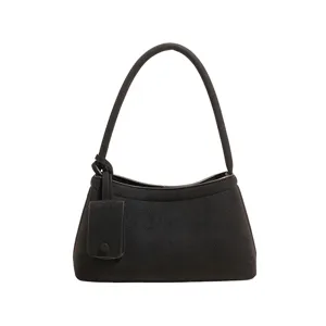 Detailed view of retro black suede shoulder bag, minimalist chic commuter handbag close up.