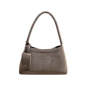 Vintage suede shoulder bag with coin pouch detail, casual elegant hobo handbag close-up.