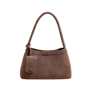 Vintage brown suede shoulder bag detail showing soft texture and compact pouch design.