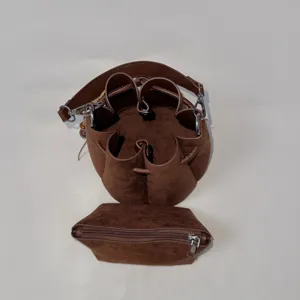 Detailansicht der braunen Wildleder-Eimerentasche mit Blütenrand und passender Tasche.