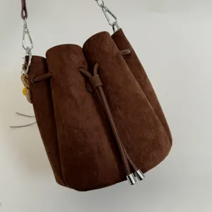 Detailansicht der braunen Vintage Veloursleder Beuteltasche mit Kordelzug und Kette.