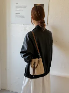 Detailansicht der retro minimalistischen Wildleder Beuteltasche mit braunem Lederriemen.