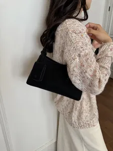 Detailed view of the retro black suede underarm shoulder bag with chic front pocket design.