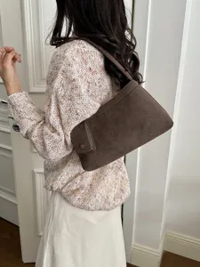 Detailed view of a retro brown suede shoulder bag showcasing soft texture and minimalist design.