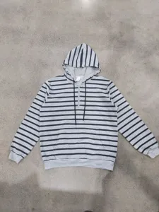 Nahaufnahme der grauschwarzen gestreiften Kapuzenpullover Tasche und Kordelzug Details.