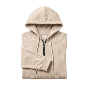 Detail view of men's waffle half-zip hooded sweatshirt with kangaroo pocket and drawstrings.