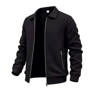 Detail view of men's black waffle knit jacket, lapel collar, metal zipper pocket.