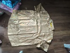 Gros plan detail de chemise homme manches courtes dore brillant style retro metallique.