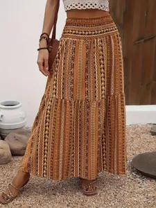 Bohemian tiered long skirt detail showcasing brown patterned print and elastic high waist.
