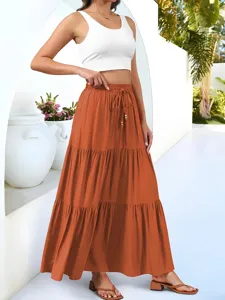 Close-up detail of casual tiered maxi skirt worn with crop top in vacation style scene.