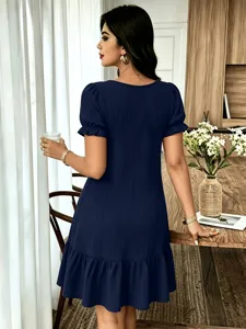 Λεπτομέρεια από κομψό σκούρο μπλε υφασμένο κοντομάνικο φόρεμα με όμορφα σχέδιο βολάν.