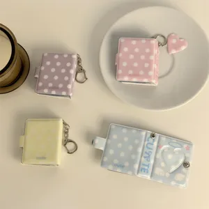 Mini polka dot photo album keychain with heart cutout and snap closure for 2-inch mini photos.