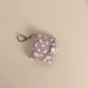 Mini purple polka dot photo album keychain with heart cutout and snap closure for 2-inch cards.