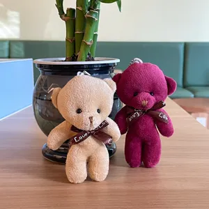 Detailansicht des süßen Plüschbär Schlüsselanhängers mit Schleife und Love-Druck.