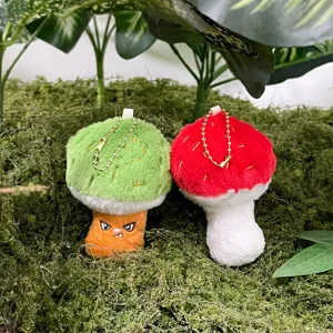 Primo piano dettagliato di simpatici portachiavi in peluche a forma di funghi su sfondo.