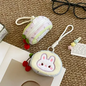 Joli porte-monnaie en peluche lapin avec pendentif cerise, idéal pour écouteurs et petits objets.