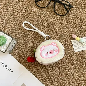 Joli porte-monnaie en peluche avec pendentif cerise pour ranger écouteurs et petits objets.