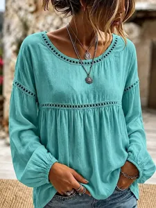 Close-up van de turquoise blouse met lange mouwen en elegante opengewerkte details.