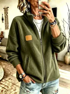 Detalle en primer plano de la chaqueta de forro polar verde oliva con textura suave.