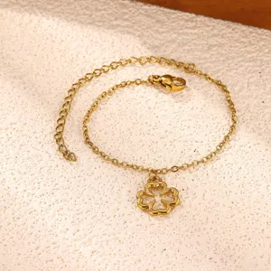 Primer plano detallado de la pulsera de cadena fina con colgante de trébol dorado