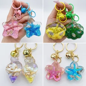Close-up detail of liquid quicksand starfish and shell keychain bag charm pendant.
