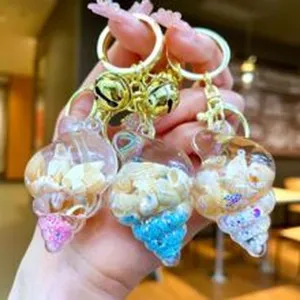 Resin shell keychain with mini seashells and glitter, featuring cute metal bells and golden ring.