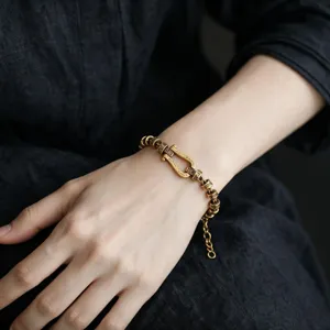 Close-up view of vintage antique gold horseshoe bracelet with detailed carved beads.