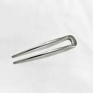 Vue détaillée d'une épingle à cheveux argentée en U élégante, accessoire de coiffure en métal.