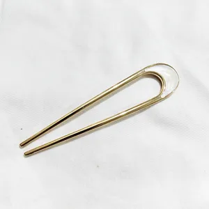 Vue détaillée d'épingle à cheveux dorée en U, fourche à cheveux métallique élégante et simple.