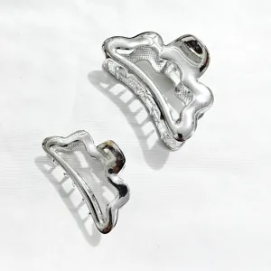 Detail view of silver metallic wavy hair claws, stylish and durable shark clip set for daily wear.