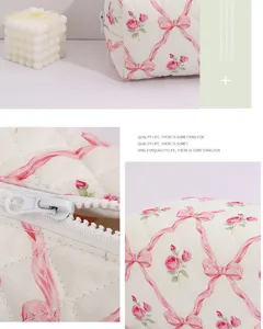 Vue détaillée de la trousse de maquillage matelassée à fleurs avec nœud et fermeture éclair.