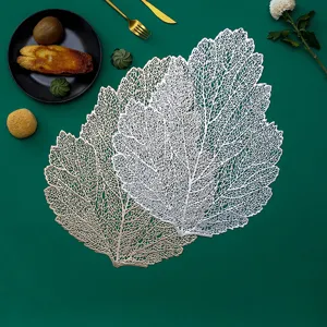 Detailed shot of hollow out leaf placemat in silver and gold showing elegant dining table setting
