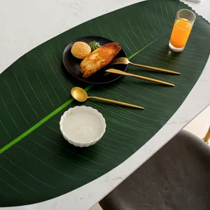 Details of decorative banana leaf PVC placemat, showing fine leaf veins and table setting.