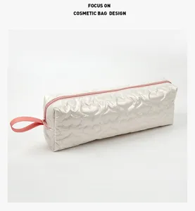 Vista dettagliata della borsa cosmetica trapuntata bianca con cuore e cerniera rosa.