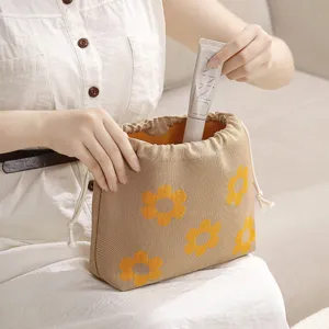 Knitted drawstring cosmetic bag with cute yellow flower pattern, portable travel makeup storage.