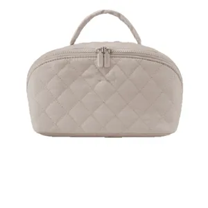Quilted cosmetic bag with top handle and double zipper, large capacity toiletry organizer.