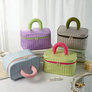 Portable quilted cosmetic bag with stylish handle, large capacity makeup storage pouch for daily use.