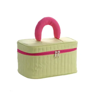 Portable quilted cosmetic bag with pink handle, large capacity makeup storage organizer.