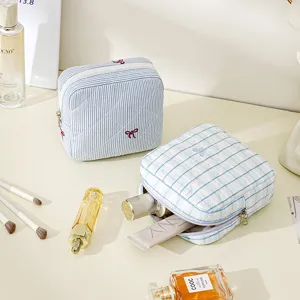Quilted cosmetic bag with cute bow embroidery, large capacity portable travel makeup storage pouch.
