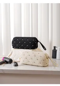 Quilted hair dryer storage bag with bow pattern, portable travel cosmetic organizer pouch.