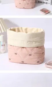 Close-up of the cute pink quilted cosmetic storage bag featuring delicate bow embroidery.