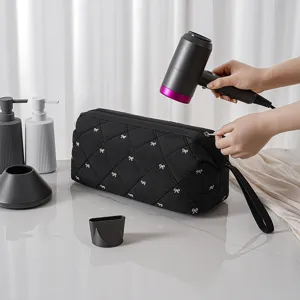 Portable travel hairdryer storage bag with quilted design and cute bows for accessories.