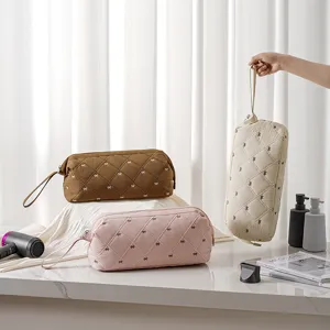 Portable quilted hairdryer storage bag with cute bow pattern, ideal for travel and daily use.