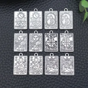 Close-up detail of silver alloy tarot card charms, vintage metal pendants for DIY jewelry making.
