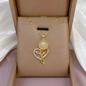 Primer plano detallado del collar colgante de corazón y girasol dorado con circonita cúbica.