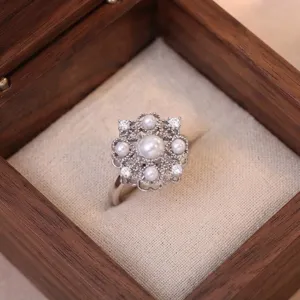 Exquisito anillo de flor de perla vintage con circones centelleantes y detalles elegantes.